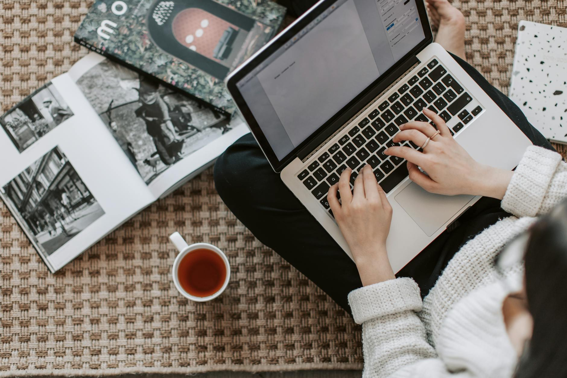 Eine Person arbeitet an einem Laptop und beschäftigt sich mit Dokumenten und Diagrammen, die die Implementierung eines QMS für den EU AI Act symbolisieren.